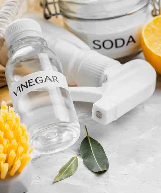 White vinegar being applied on black mold on a bathroom wall to show how long vinegar can stay on mold overnight.